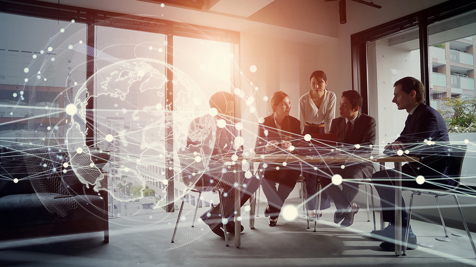 Team of people meeting in an office with graphic of globe overlaid