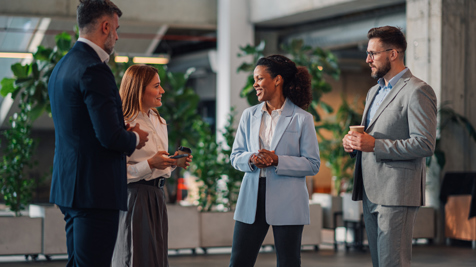 People stood networking in a bright open office space