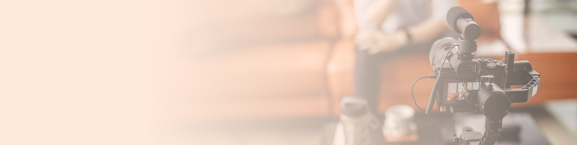 a video camera pointed at a man sitting on a sofa