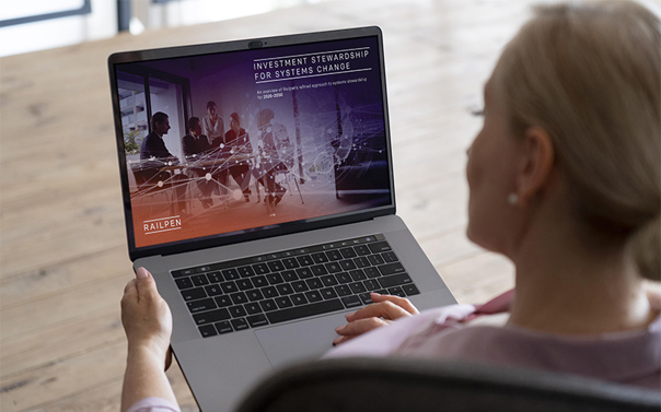 Laptop displaying Railpen’s 'Investment stewardship for systems change' report on screen, viewed from behind a seated user at a desk.