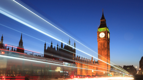 Long exposure of light trails from vehicles passing by Big Ben and the Houses of Parliament at dusk in London.