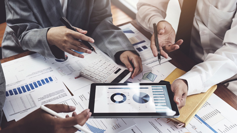 Team of people working together on financial and investment reports