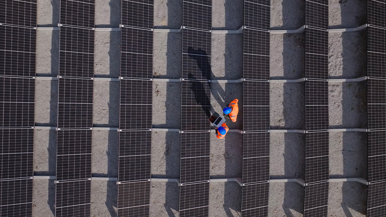 Two construction workers photographed standing on concrete from above in high vis protective gear