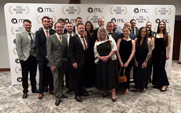 A group of people from Railpen dressed in formal evening wear standing together on a patterned carpet in front of a branded backdrop for the SDI Awards 2026 and ITIL. The backdrop features repeating logos and laurel designs. The group is arranged in a semi‑formal pose, with individuals wearing suits, long dresses and other formal attire. The setting appears to be an indoor event or awards ceremony.