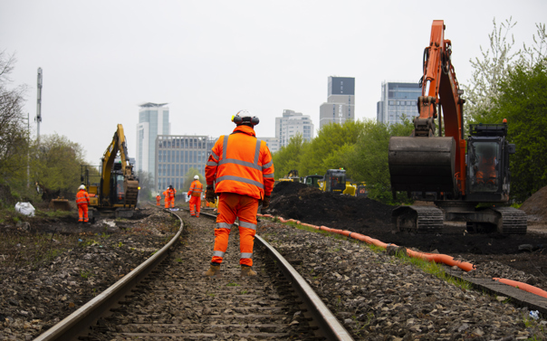 Maintenance workers on railway tracks wearing high-vis safety gear