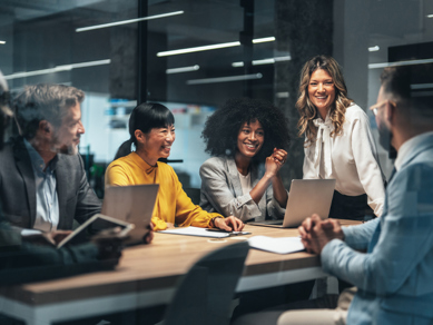 Colleagues laughing together in a meeting room
