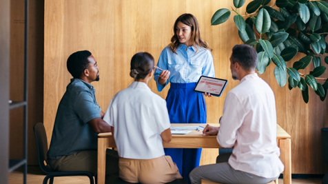 Office workers in conversation in brightly lit meeting space