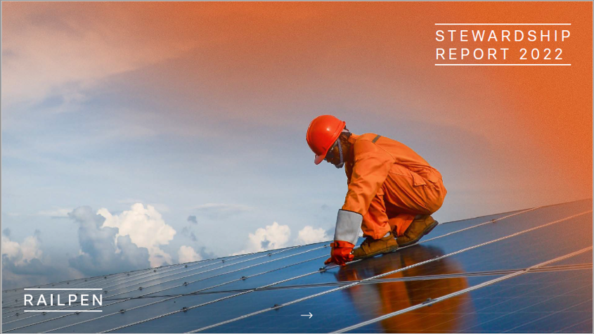 Man wearing a hard hat and orange overalls on a roof with solar panels and blue sky in the background